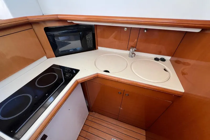  Yacht Photos Pics 2005 Jeanneau Prestige 36 yacht kitchen with stove, microwave, and sink.