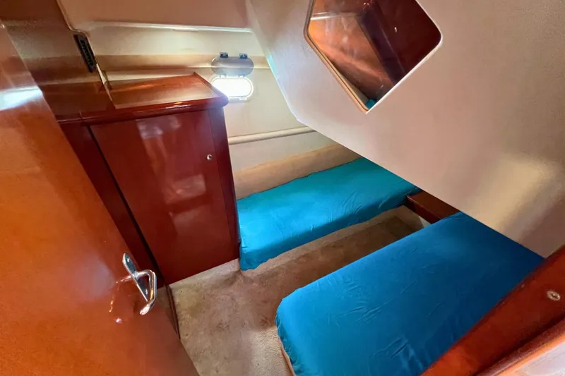  Yacht Photos Pics 2005 Jeanneau Prestige 36 cabin with twin beds and wooden cabinetry.