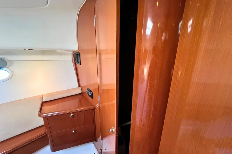  Yacht Photos Pics Interior of 2005 Jeanneau Prestige 36 yacht with polished wood finish and storage cabinets.