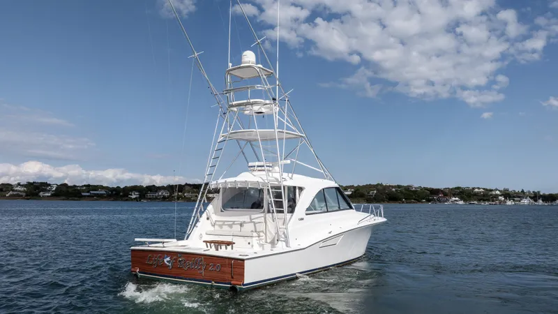 Life Of Reilly 2.0 Yacht Photos Pics 2012 Cabo 44 HTX yacht cruising on a calm sea under a partly cloudy sky.