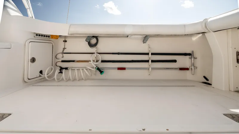 Life Of Reilly 2.0 Yacht Photos Pics Fishing equipment storage on 2012 Cabo 44 HTX boat deck, featuring rods and coiled hose.