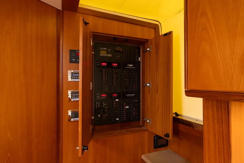 Life Of Reilly 2.0 Yacht Photos Pics Electrical panel inside 2012 Cabo 44 HTX yacht, featuring wooden cabinetry and control switches.