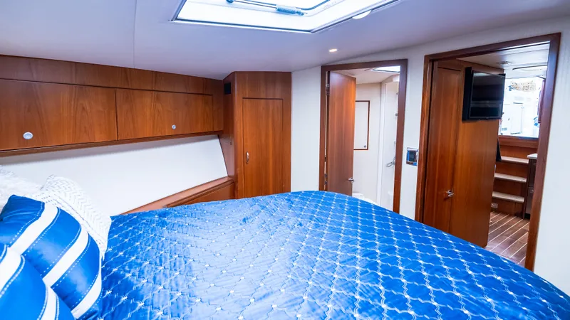 Life Of Reilly 2.0 Yacht Photos Pics Luxurious cabin interior of 2012 Cabo 44 HTX yacht with blue bedding and wooden accents.