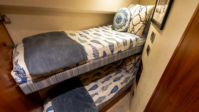 Life Of Reilly 2.0 Yacht Photos Pics Bunk beds with nautical-themed bedding in a 2012 Cabo 44 HTX yacht cabin.