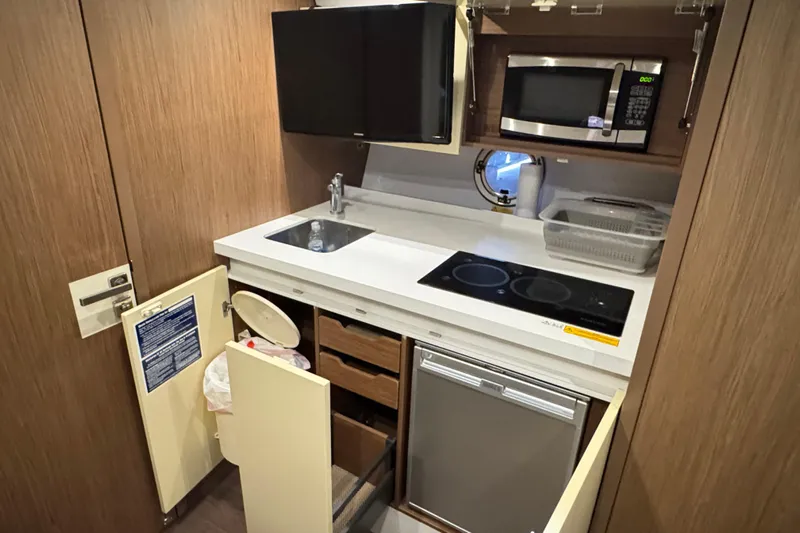  Yacht Photos Pics Compact kitchen in 2016 Beneteau Gran Turismo 40 yacht with stove, sink, and microwave.