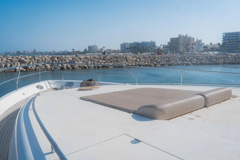 Odeya Yacht Photos Pics Luxurious 2004 Princess 82 Motor Yacht deck with sunbed, overlooking a serene marina.