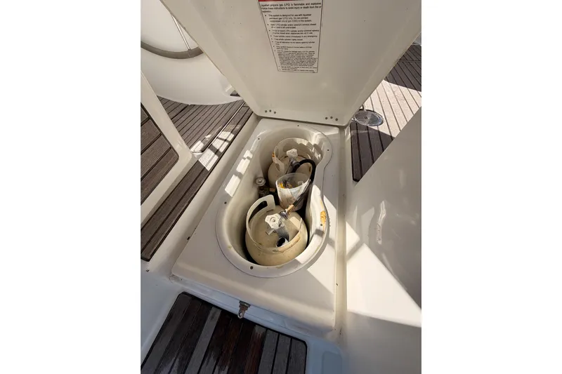 Set Free Yacht Photos Pics Storage compartment on 2007 Beneteau 49 yacht with propane tanks and wooden deck.