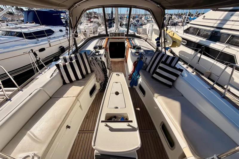 Set Free Yacht Photos Pics 2007 Beneteau 49 yacht cockpit with striped cushions, docked in marina.