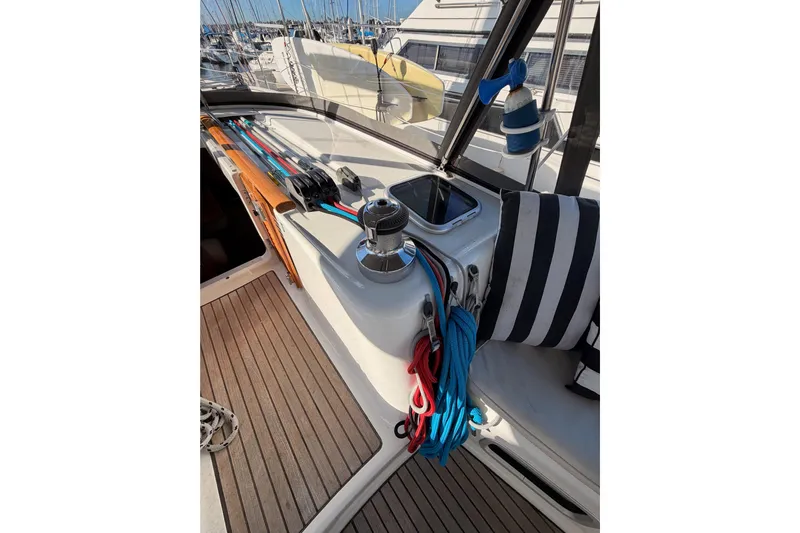 Set Free Yacht Photos Pics Cockpit of 2007 Beneteau 49 sailboat with winch, ropes, and striped cushion.