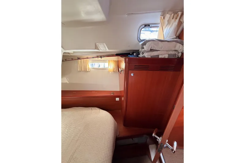 Set Free Yacht Photos Pics Interior cabin of 2007 Beneteau 49 yacht with bed, wooden cabinetry, and window.