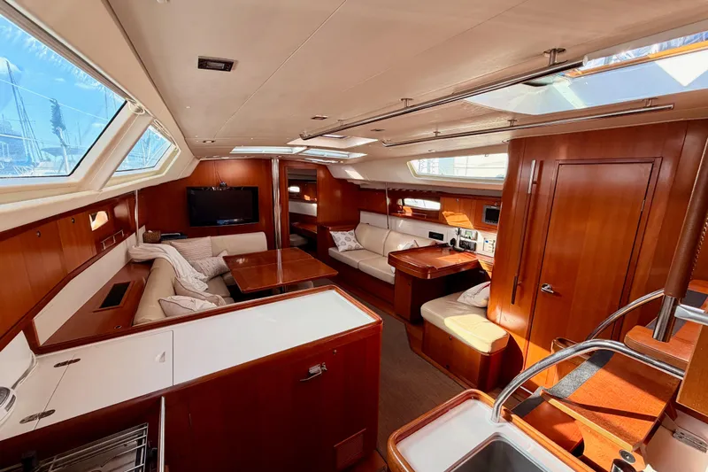 Set Free Yacht Photos Pics Luxurious interior of a 2007 Beneteau 49 yacht with elegant wood finishes and spacious seating.