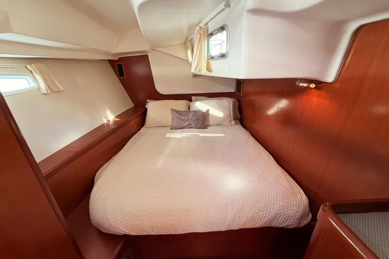 Set Free Yacht Photos Pics Cozy cabin interior of 2007 Beneteau 49 yacht with wooden accents and comfortable bedding.
