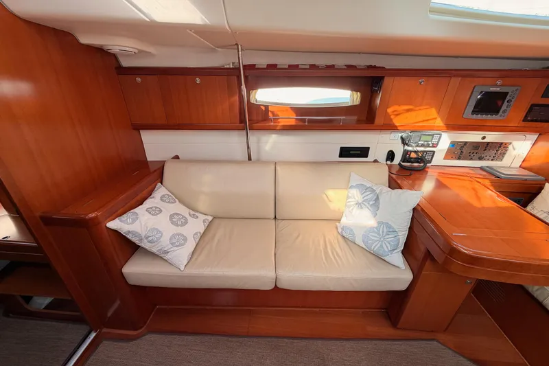 Set Free Yacht Photos Pics Interior of 2007 Beneteau 49 yacht with beige sofa and wooden cabinetry.