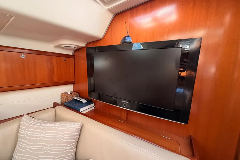 Set Free Yacht Photos Pics Interior of 2007 Beneteau 49 yacht with TV, wooden paneling, and cozy seating area.
