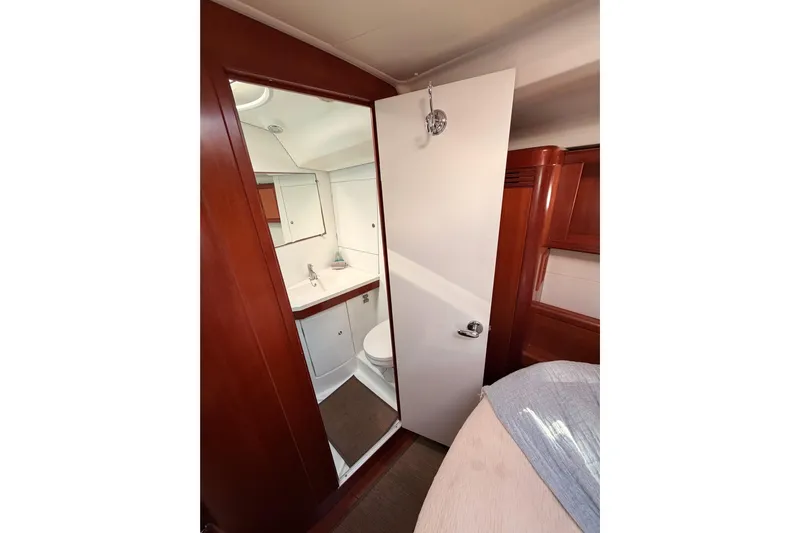 Set Free Yacht Photos Pics Interior view of 2007 Beneteau 49 yacht bathroom with wooden accents and modern fixtures.