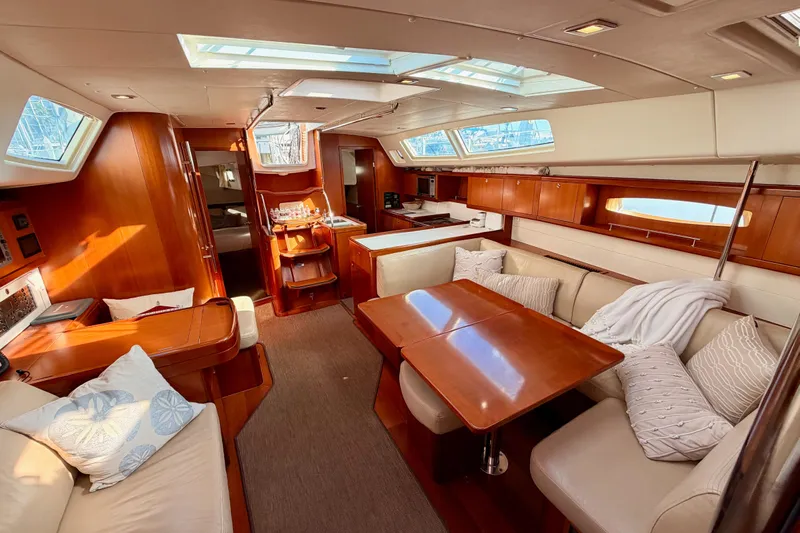 Set Free Yacht Photos Pics Luxurious interior of 2007 Beneteau 49 yacht with elegant wood finish and plush seating.