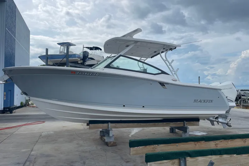  Yacht Photos Pics 2022 Blackfin 272 DC boat on dry dock, cloudy sky background.