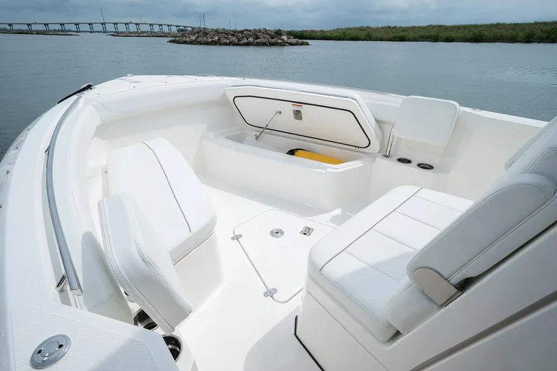  Yacht Photos Pics Manufacturer Provided Image: 2025 Pursuit S 268 Sport boat interior with white seating and storage, on calm water.