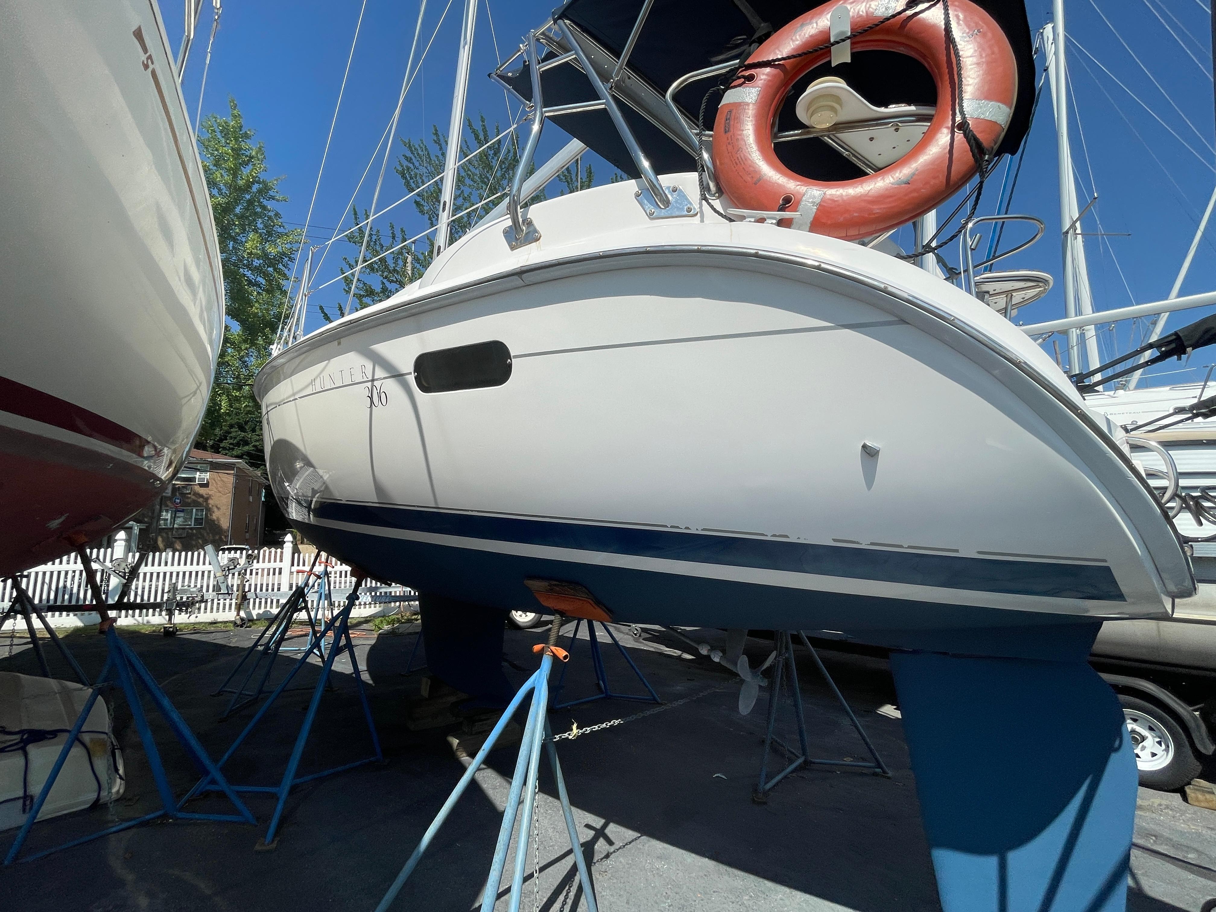 2001 Hunter 306 sailboat on stands, with a visible life preserver and clear blue sky.