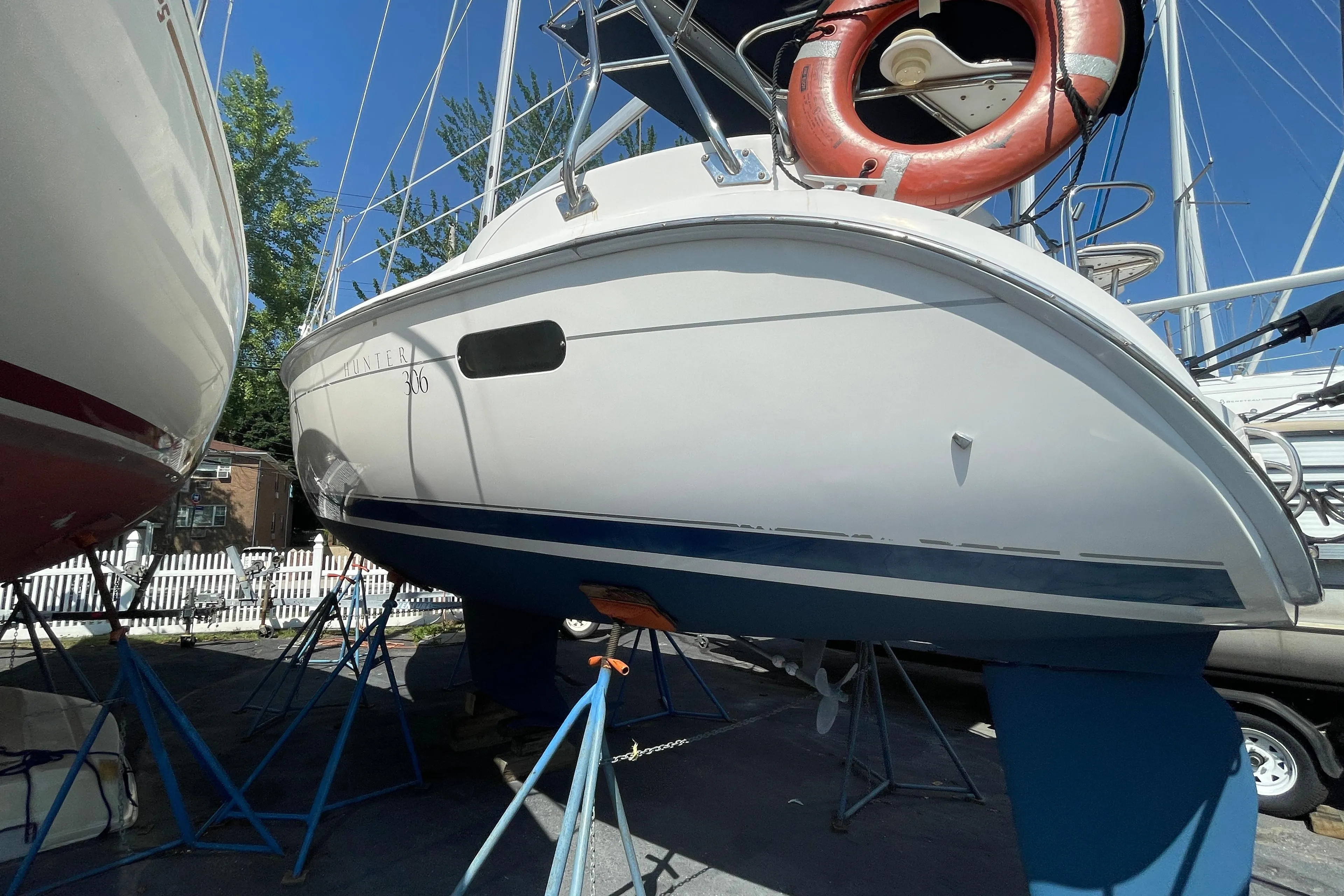 2001 Hunter 306 sailboat on stands, with a visible life preserver and clear blue sky.