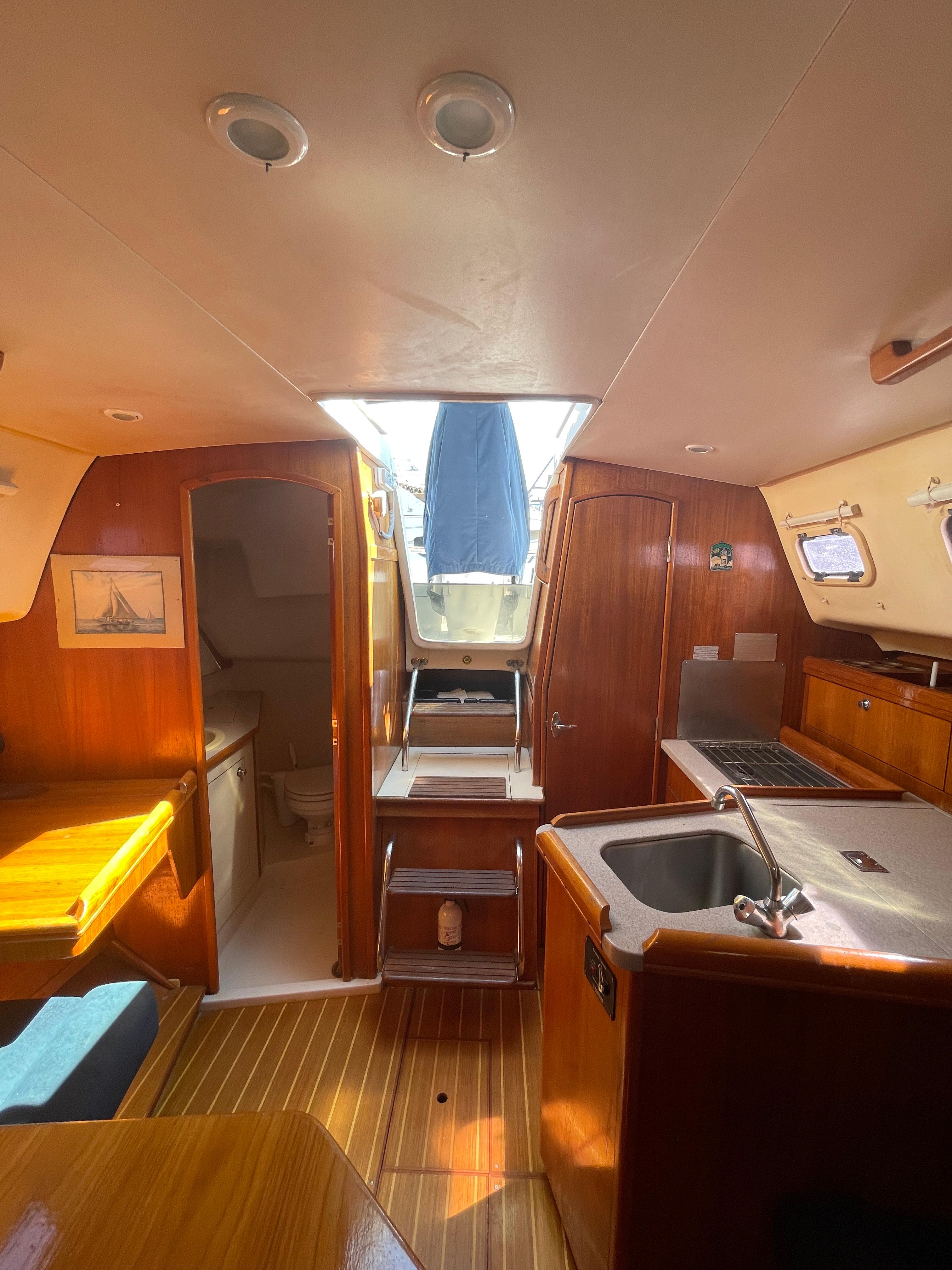 Interior of 2001 Hunter 306 sailboat with wood finish and compact kitchen area.