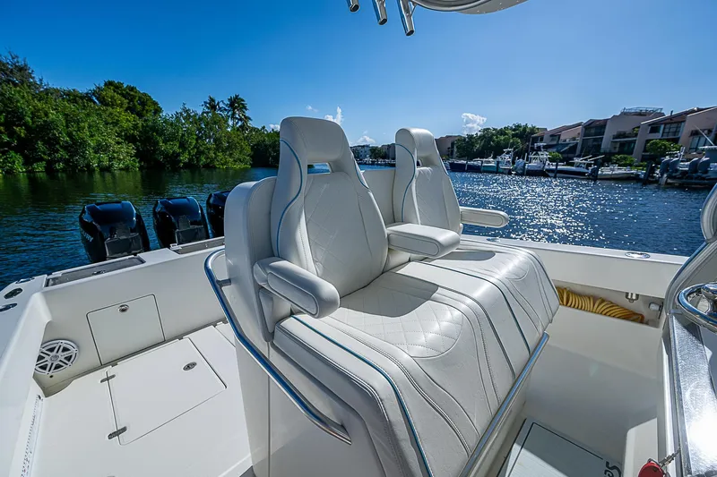  Yacht Photos Pics 2018 SeaVee 370z boat with luxurious seating, docked by a scenic waterfront.