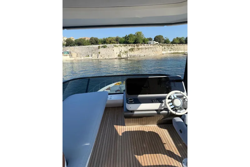  Yacht Photos Pics Flybridge of 2022 Azimut 68 FLY yacht with modern helm and scenic waterfront view.