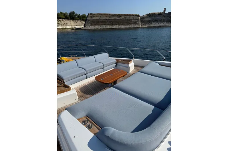  Yacht Photos Pics Luxurious 2022 Azimut 68 FLY yacht deck with comfortable seating and scenic waterfront view.