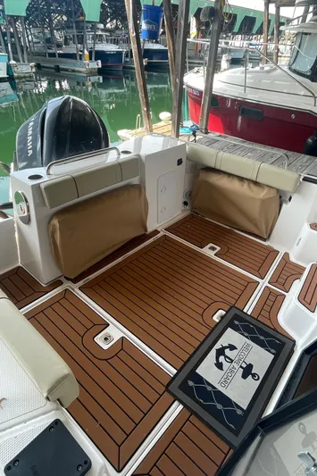 Beautiful Boat At Great Price! Yacht Photos Pics 2023 Ranger Tugs R-25 boat deck with wood finish and seating at a marina.