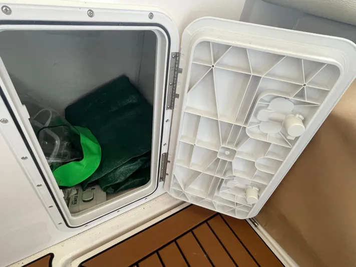 Beautiful Boat At Great Price! Yacht Photos Pics Open storage compartment on 2023 Ranger Tugs R-25 boat with green items inside.