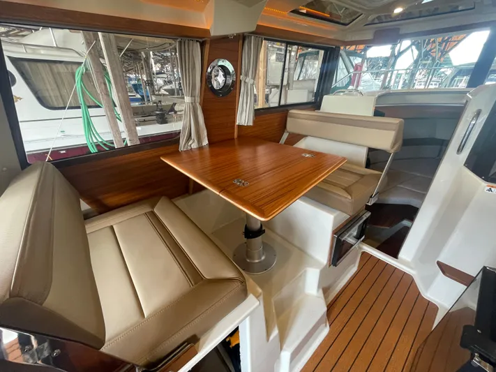 Beautiful Boat At Great Price! Yacht Photos Pics Interior of 2023 Ranger Tugs R-25 with seating and wooden table.