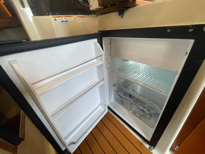 Beautiful Boat At Great Price! Yacht Photos Pics 2023 Ranger Tugs R-25 boat interior with open refrigerator, showcasing storage space.