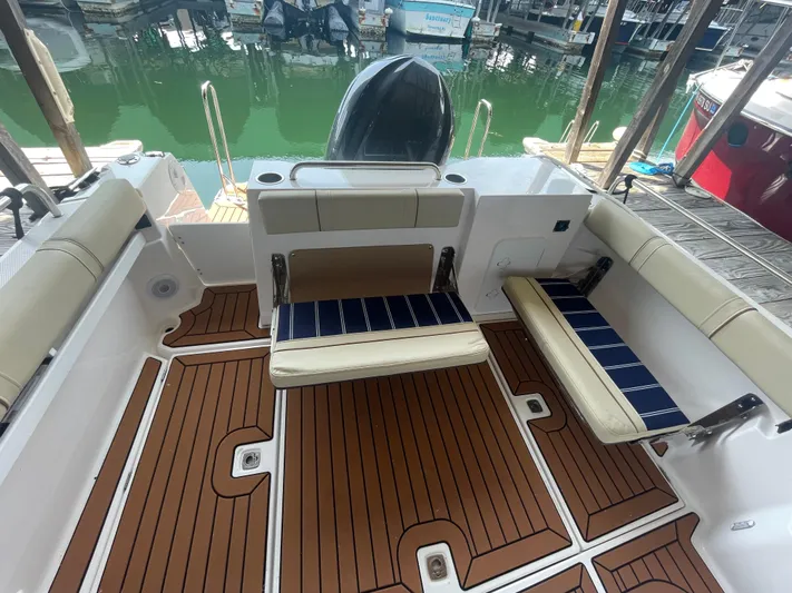 Beautiful Boat At Great Price! Yacht Photos Pics 2023 Ranger Tugs R-25 boat interior with teak flooring and cushioned seating.