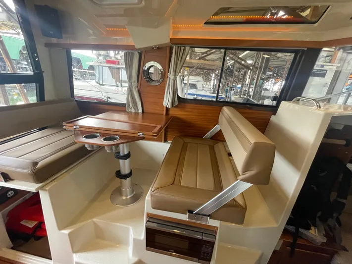 Beautiful Boat At Great Price! Yacht Photos Pics 2023 Ranger Tugs R-25 interior with brown seating and wooden table.