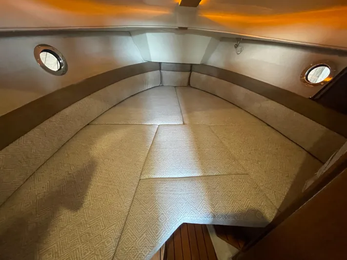 Beautiful Boat At Great Price! Yacht Photos Pics 2023 Ranger Tugs R-25 interior cabin with cushioned seating and porthole windows.