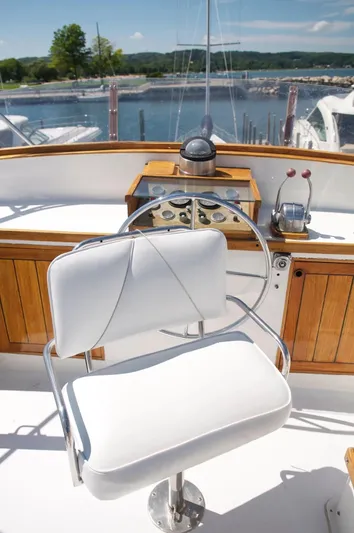 Shangri-la Yacht Photos Pics 1978 Cheoy Lee Ocean Access yacht helm with white captain's chair and scenic marina view.