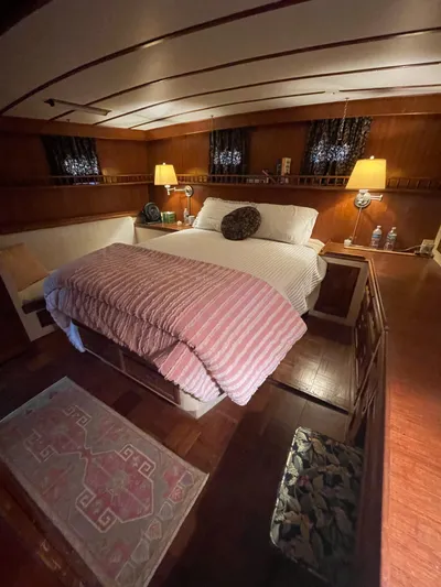 Shangri-la Yacht Photos Pics Cozy bedroom interior on 1978 Cheoy Lee yacht with wood paneling and ambient lighting.