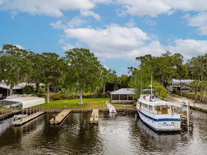 Shangri-la Yacht Photos Pics 1978 Cheoy Lee yacht docked at ocean access deeded slips, surrounded by lush greenery and calm waters.