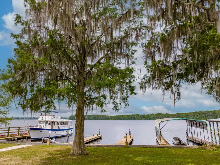 Shangri-la Yacht Photos Pics 1978 Cheoy Lee boat docked at serene lakeside with lush trees and ocean access deeded slips.