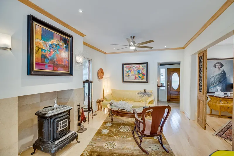 Shangri-la Yacht Photos Pics Cozy living room with vintage decor, colorful artwork, and a wood-burning stove.