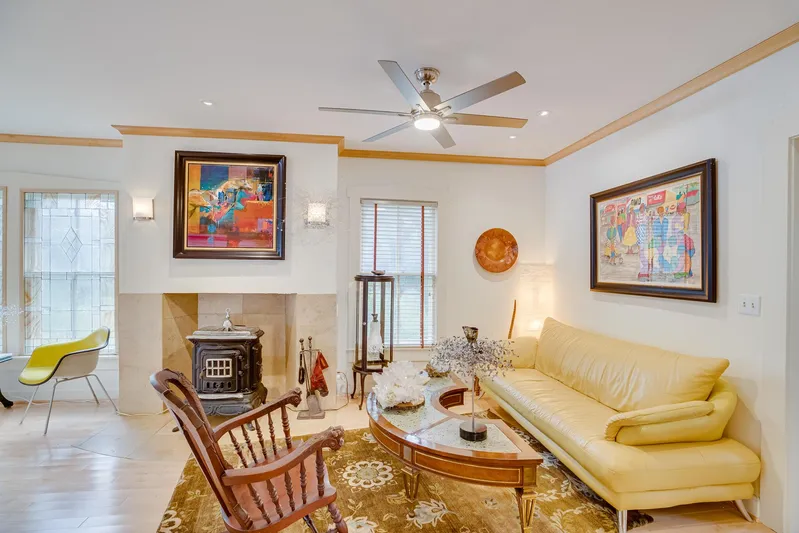 Shangri-la Yacht Photos Pics Cozy living room with modern decor, yellow sofa, wood stove, and colorful artwork.