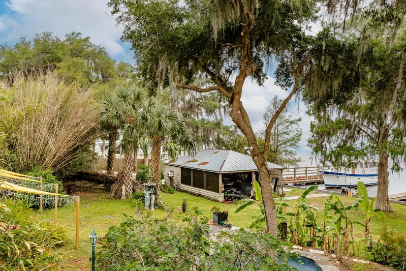 Shangri-la Yacht Photos Pics Lush waterfront property with trees, a small building, and a docked boat, Cheoy Lee 1978.