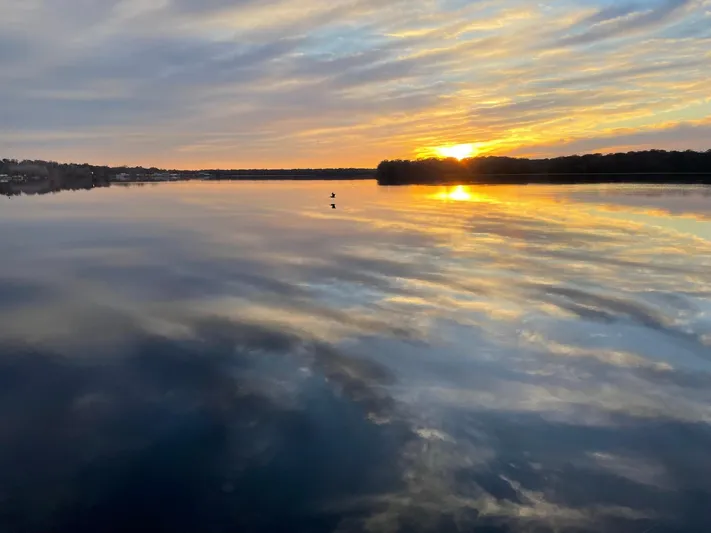 Shangri-la Yacht Photos Pics Sunset over calm waters with vibrant sky reflections, 1978 Cheoy Lee Ocean Access Deeded Slips.