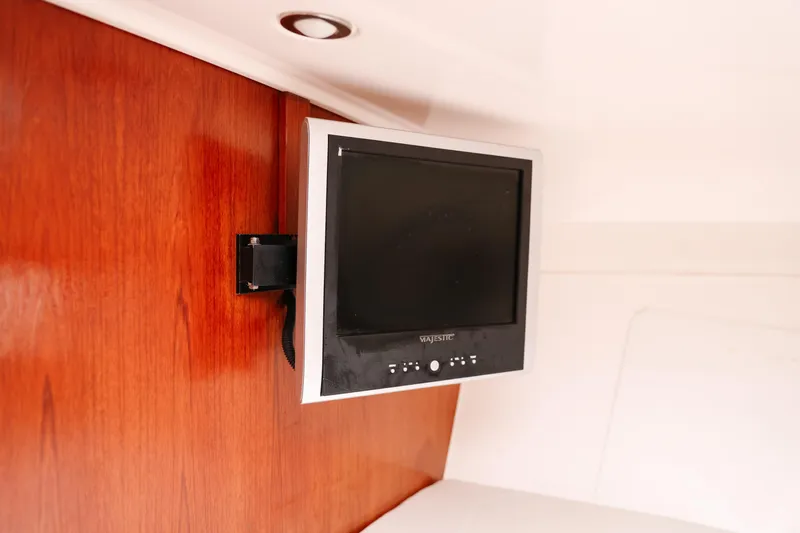  Yacht Photos Pics Wall-mounted TV inside 2010 Everglades 350LX boat cabin with wooden paneling.