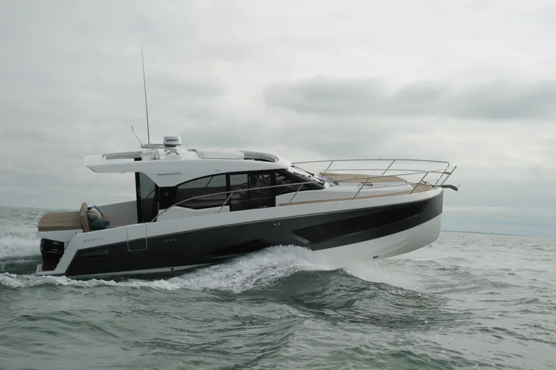  Yacht Photos Pics 2025 Skamander Monaco Coupe yacht cruising on open water under cloudy skies.