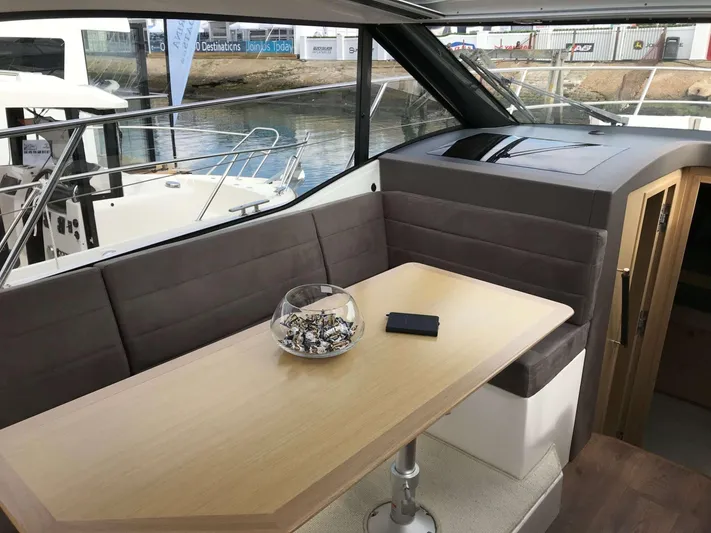  Yacht Photos Pics Interior of 2025 Skamander Monaco Coupe yacht with table and seating area.