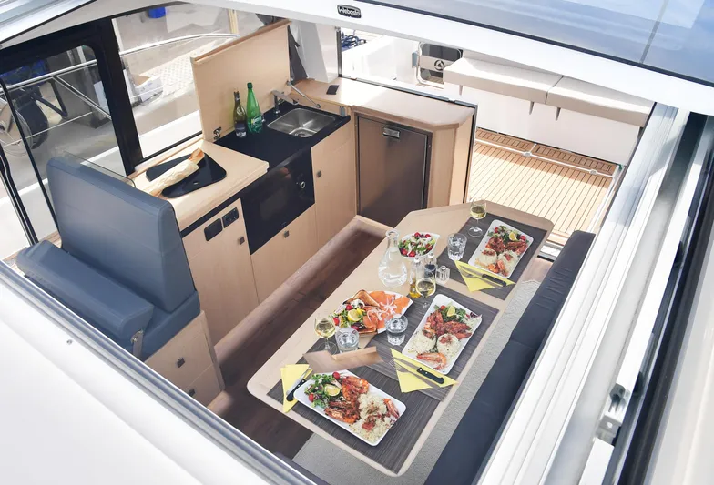  Yacht Photos Pics Interior of 2025 Skamander Monaco Coupe yacht with elegant dining setup and modern kitchen amenities.
