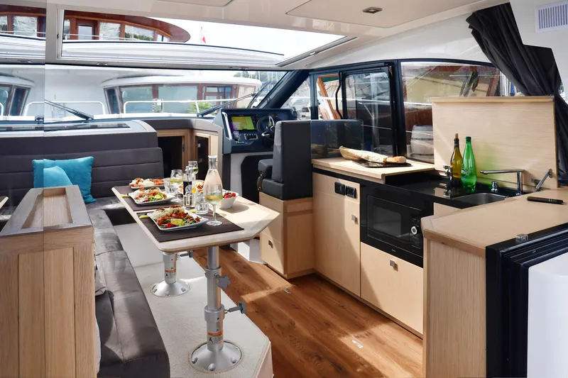  Yacht Photos Pics Luxurious interior of 2025 Skamander Monaco Coupe yacht with dining and kitchen area.