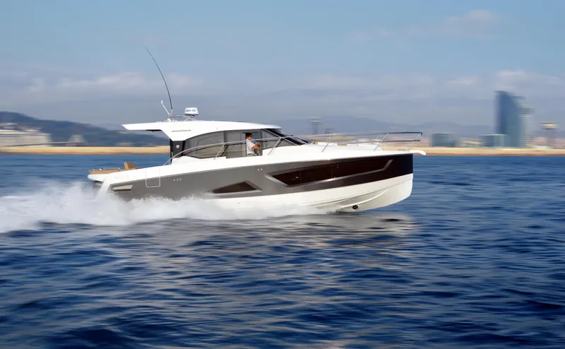  Yacht Photos Pics 2025 Skamander Monaco Coupe cruising on open water, cityscape in background.