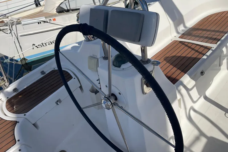  Yacht Photos Pics Steering wheel of a 2008 Hunter 49 sailboat with wooden deck details.